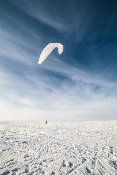 Kiteboarder dengan layang-layang biru di salju — Stok Foto