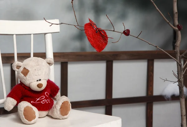 Valentine decorations. Teddy bear with red knitted heart — Stock Photo, Image