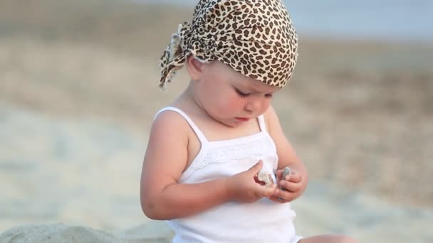 Bebê menina sentado e brincando na praia — Vídeo de Stock