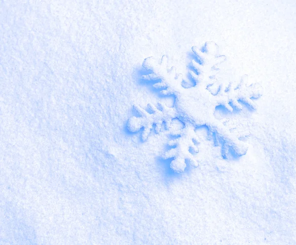 Floco de neve contra um fundo de neve — Fotografia de Stock