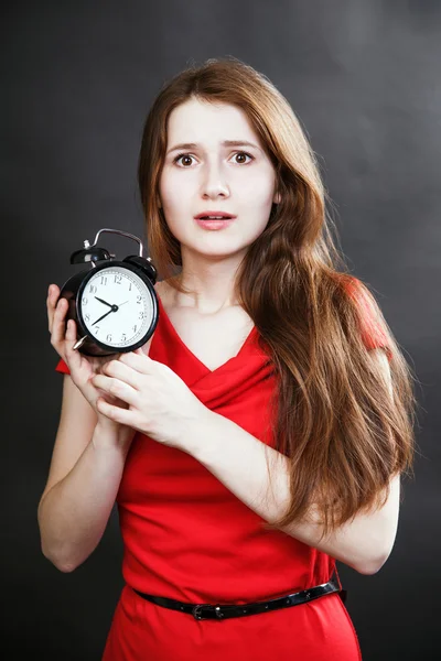 Mädchen im roten Kleid spät mit Wecker — Stockfoto