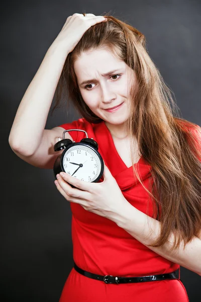 Girl in red dress late with alarm clock — Stock Photo, Image