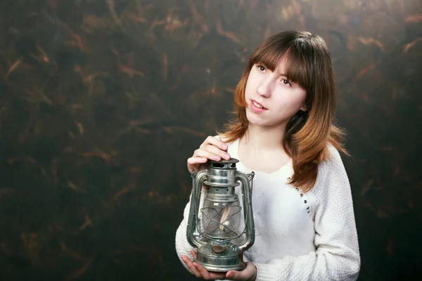 Beautiful girl with a kerosene lamp in hands — Stock Photo, Image