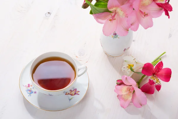 Ретро натюрморт з чашкою чаю та квітів — стокове фото