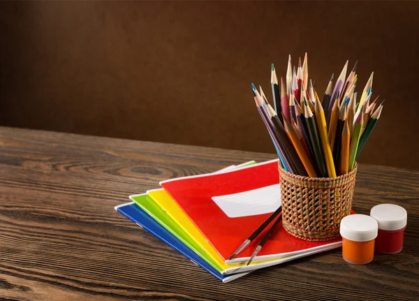 Lápices, pinturas y pinceles sobre mesa de madera  . — Foto de Stock