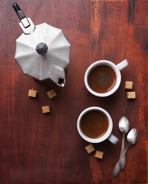 Dua cangkir espresso dengan potongan gula tebu dan pembuat kopi Italia — Stok Foto