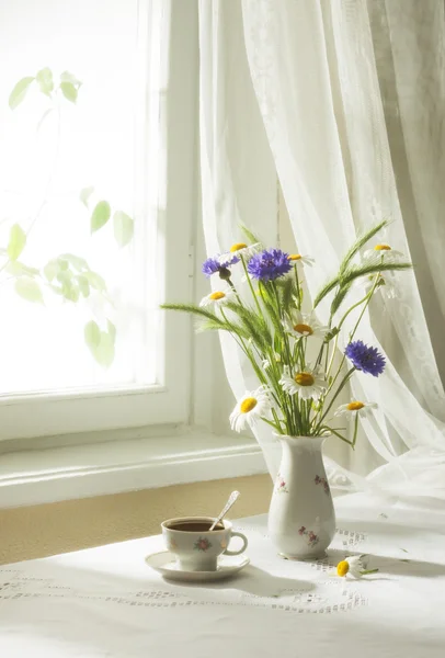 Blommor och kopp kaffe — Stockfoto