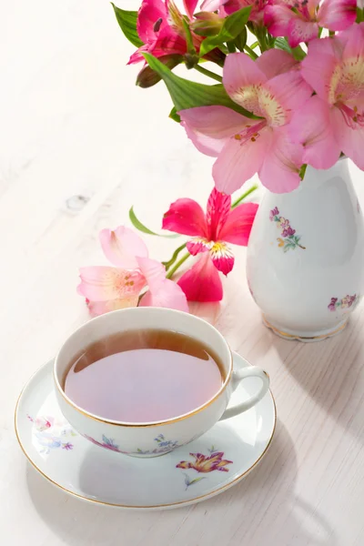 Ретро натюрморт з чашкою чаю та квітів — стокове фото