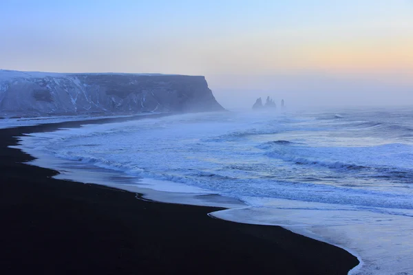 Landschap met strand van zwart zand en de zee stapels op de achtergrond — Stockfoto