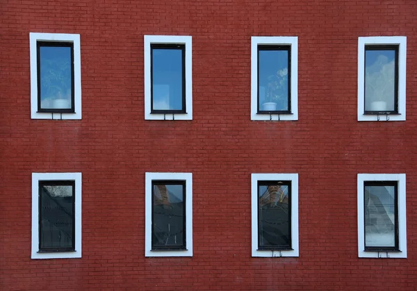 Восемь окон на стене из красного кирпича — стоковое фото