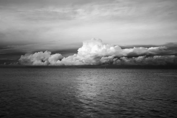 Storm clouds over the sea, black and white.