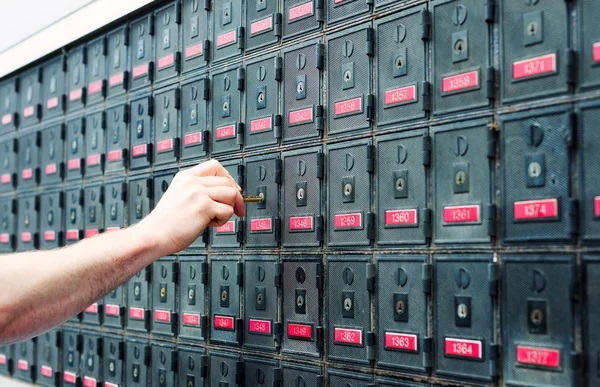 En man som öppnar brevlådan på postkontoret — Stockfoto