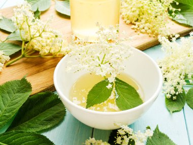 Elderberry şurubu tahtanın üzerinde çiçekler olan ev yapımı bal. Sığ dof.