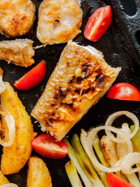 Yemek yapmak ve sağlıklı yemek yemek. Fırın tavası, fırında patates, balık bifteği ve soğanlı domates. Patates ve deniz ürünleri ile ev yapımı sağlıklı yemek..