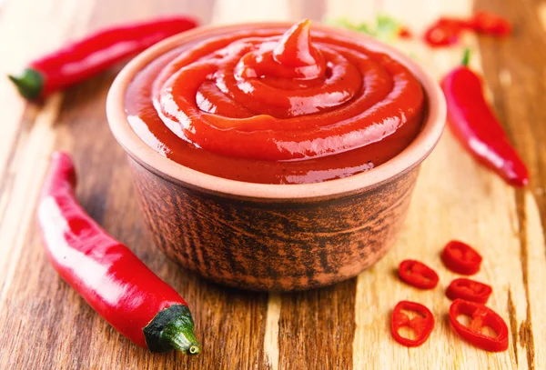 Salsa de chile rojo sobre fondo de madera — Foto de Stock