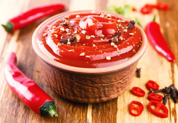 Salsa de chile rojo sobre fondo de madera — Foto de Stock