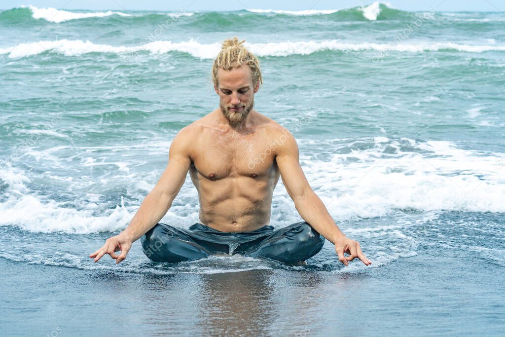 Athlete man practicing in ocean waves