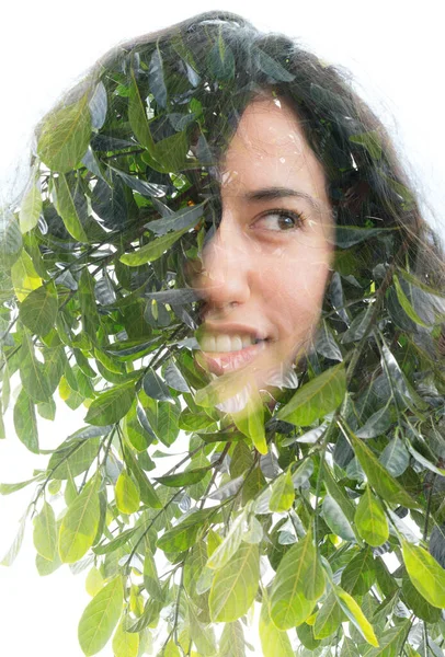 Una doppia esposizione di una mezza sorridente giovane donna ritratto e foglie di albero verde — Foto Stock