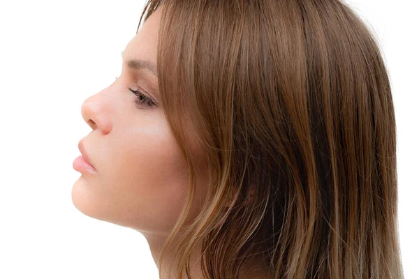 A young blond womans profile against white background — Stock Photo, Image