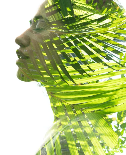 A double exposure portrait young woman profile with her eyes closed against white background and palm tree leaves —  Fotos de Stock