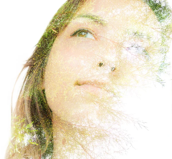 A half disappearing double exposure portrait of a dreamy young woman looking away from the camera —  Fotos de Stock