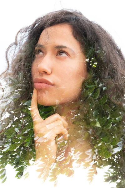 Un ritratto doppio esposizione di una giovane donna premurosa con i capelli ricci e fogliame verde — Foto Stock