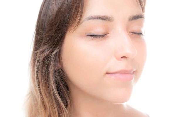 Een jonge mooie brunette met haar ogen gesloten tegen witte achtergrond — Stockfoto