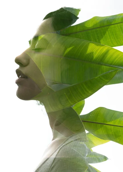 A double exposure portrait young woman profile with her eyes closed against white background and tropical foliage — Stock Photo, Image