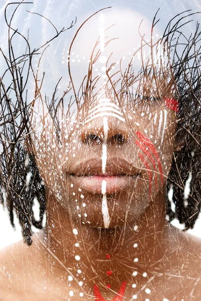 A young mans face dissolving into bare branches — Stock Photo, Image