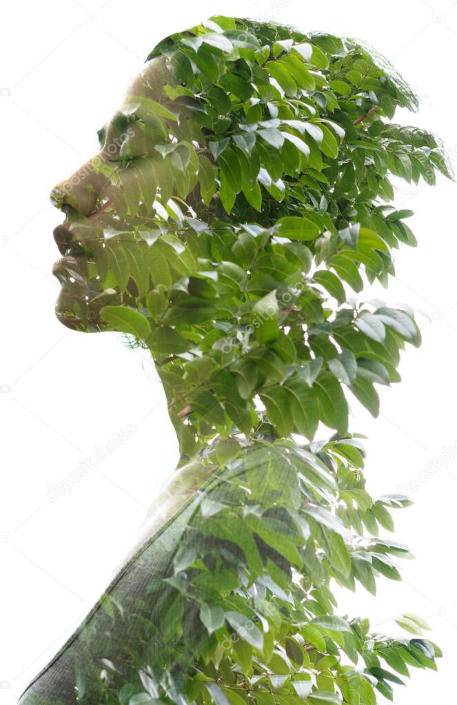 A double exposure portrait young woman profile with her eyes closed against white background and tree leaves