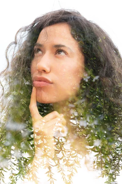 Een doulbe belichting portret van een attente jonge vrouw met krullend haar en takken met bladeren — Stockfoto