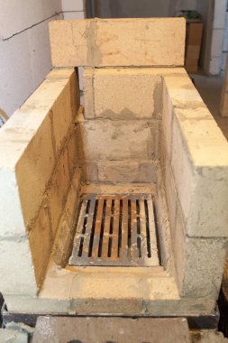 Köy evindeki köpük bloklardan geliştirilmemiş iç kısımlarda ateşe dayanıklı malzemeden inşa edilen sauna ocağının yakın görüntüsü.