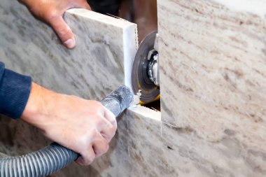 Esnaf, mermer mutfak tezgahının kenarlarını el testeresiyle keser.