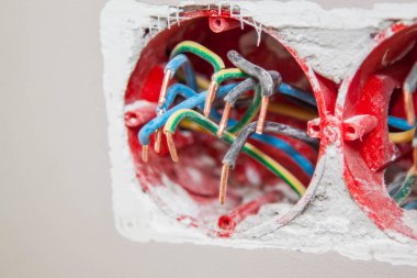 İnşaat alanında elektriğe hazırlanmak için beton duvardaki deliklere elektrik kabloları ve kablolar yerleştirilmiş.