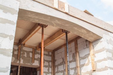 Kır evindeki ahşap işçilikle girişin üzerindeki kemer manzarası köpük bloklardan inşa ediliyor.