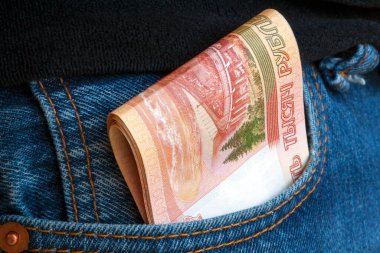 Beş bin ruble ya da kot pantolonun cebinden çıkan banknotlar. Parasal rüşvet kavramı. Tüm kazanılan paralar krediyle verilir..