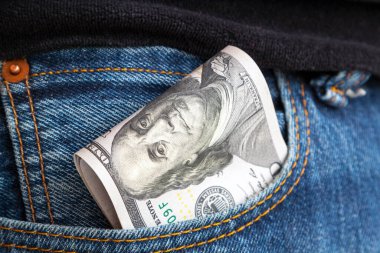 Kotun cebinden çıkan bir tomar 100 dolarlık banknot. Nakit rüşvet kavramı. Kazandığın tüm para krediye verilir..