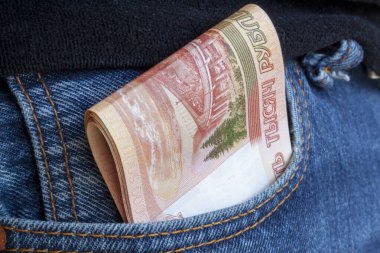 Beş bin ruble ya da kot pantolonun cebinden çıkan banknotlar. Parasal rüşvet kavramı. Tüm kazanılan paralar krediyle verilir..