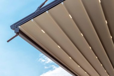 Metal çerçeveli tente ve mavi güneşli gökyüzüne karşı drenaj borusu. ev için modern gölgeleme