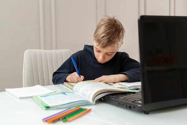 Boy Escribe Las Tareas Cuaderno Recibidas Profesor Pantalla Del Ordenador — Foto de Stock