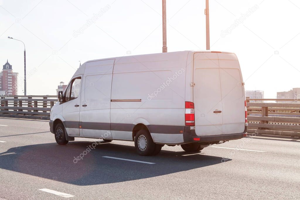 Fast delivery van drives on highway through city. commercial van is delivering cargo