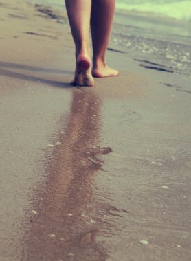 Kumsalda yürüyen bir kadın