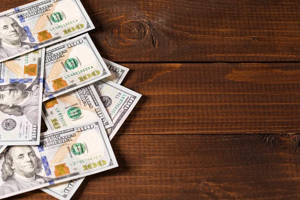 Heap of dollars bills on wooden surface — Stock Photo, Image