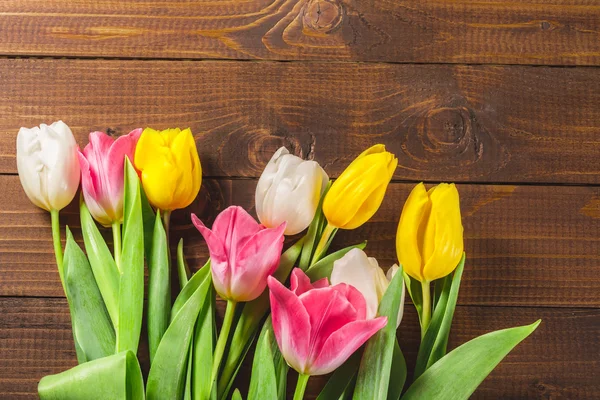 Csokor tulipán a fa felülettel — Stock Fotó