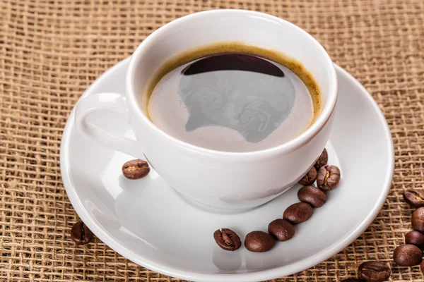 Vit kaffekopp och kaffebönor — Stockfoto