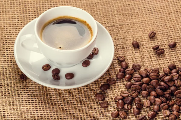 Vit kaffekopp och kaffebönor — Stockfoto