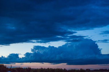 Çayırın üzerinde parlak günbatımı manzarası ve üzerinde turuncu gökyüzü. Arka plan olarak şaşırtıcı yaz gündoğumu. 