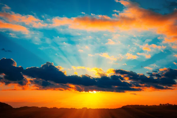 Hermoso paisaje de puesta de sol ardiente en el prado y el cielo naranja por encima de ella. Increíble amanecer de verano como fondo. —  Fotos de Stock