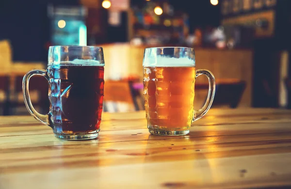 Cerveja em um balcão de madeira bar no pub — Fotografia de Stock