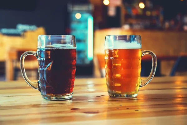 Cerveja em um balcão de madeira bar no pub — Fotografia de Stock